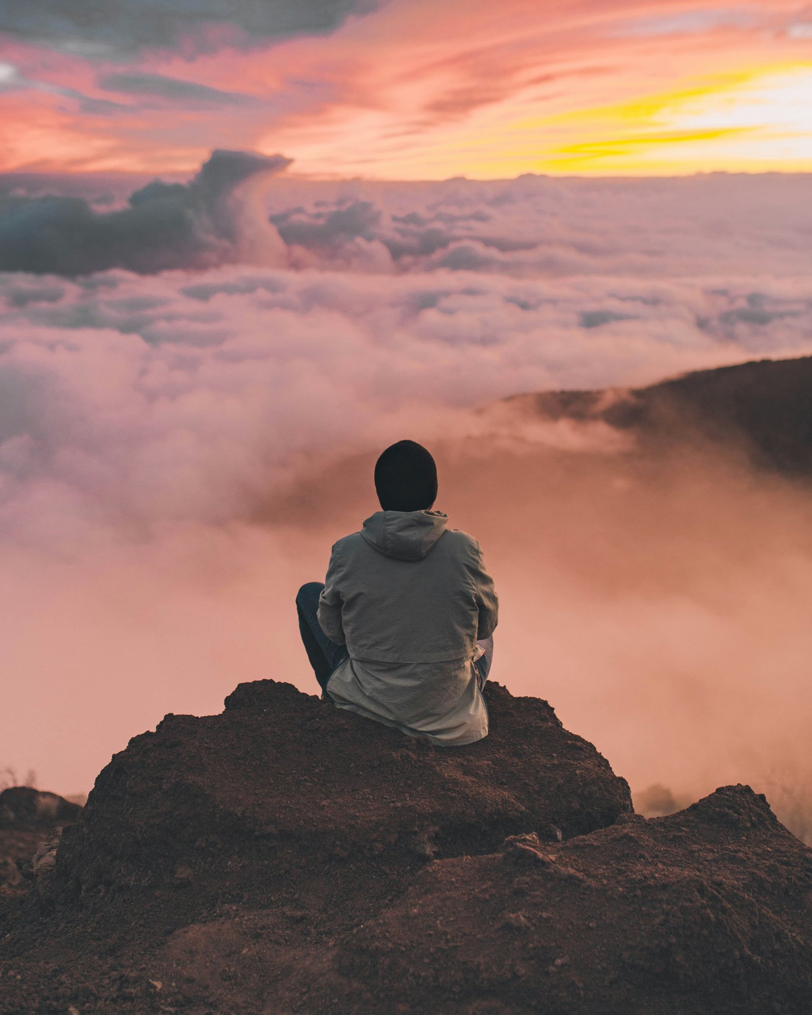 Person looking over clouds at sunrise