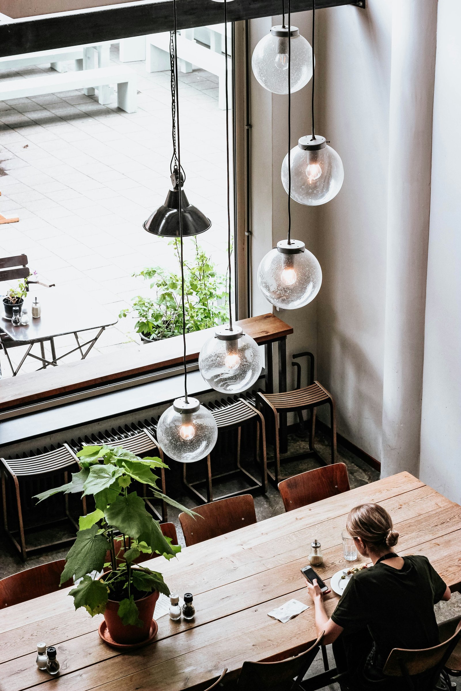 Calm workspace with hanging lights and a person at a table